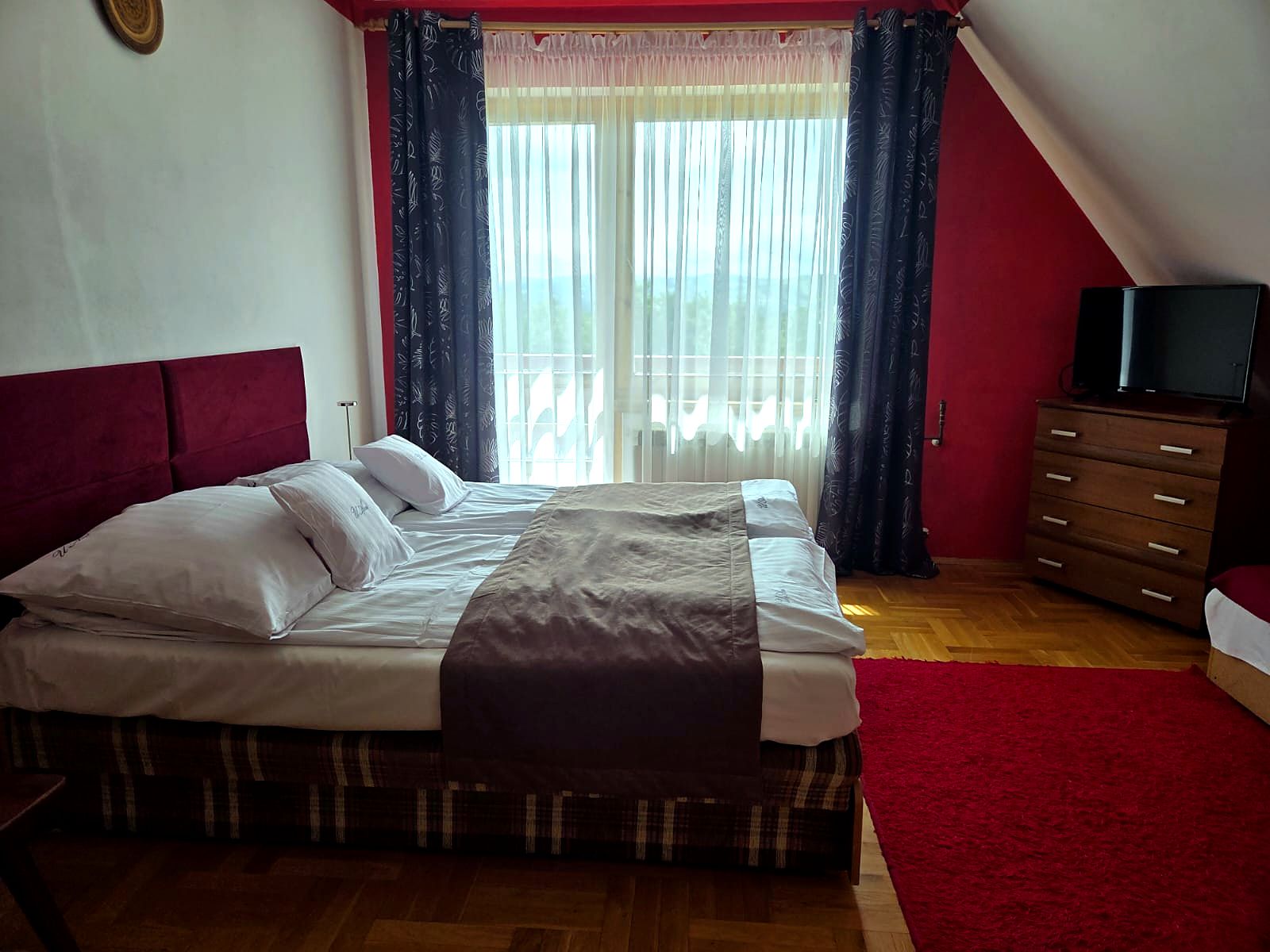 Pokój z czerwonym akcentem i balkonem